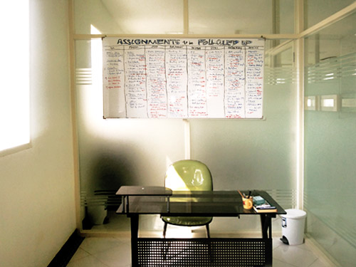 Staff cubicle with a desk and follow-up board